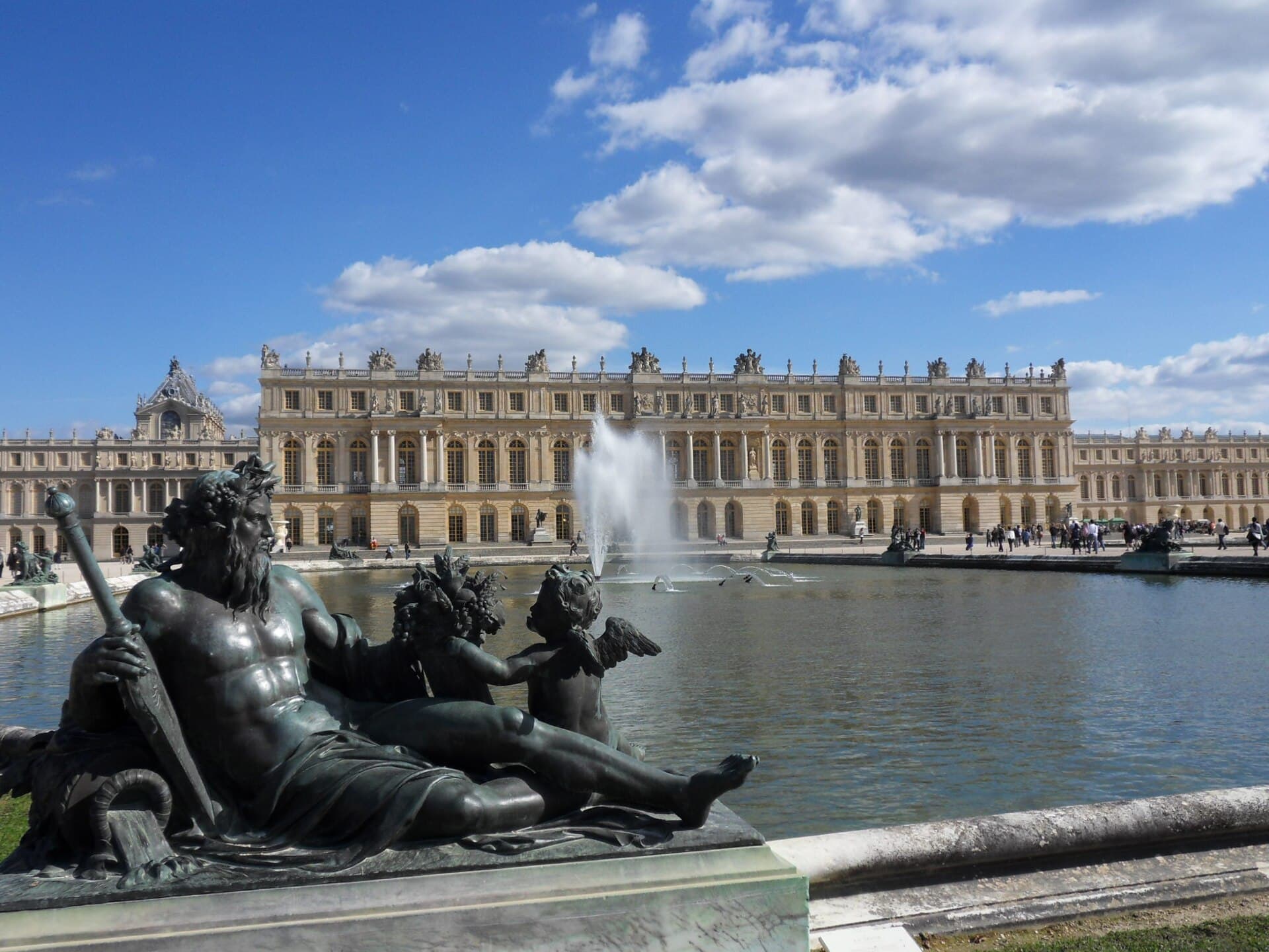 The Palace of Versailles and its formal gardens on a sunny day